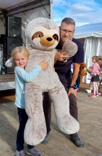 Überraschte und überglückliche Gewinnerin eines Riesen-Teddys zur Plüschtier-Party in Kahnsdorf 2022.